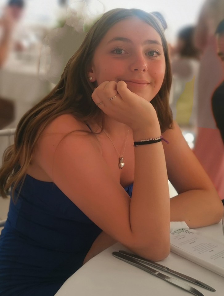 a girl sits at a table with a menu in front of her