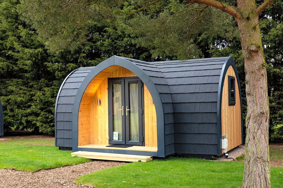 a small wooden house with a gray roof