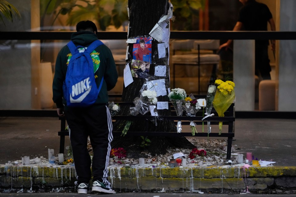 A fan stands in front of a makeshift memorial outside the hotel in the Palermo neighbourhood of the Argentine capital