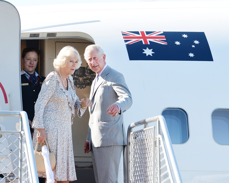 a man and woman are walking out of an airplane with an australian flag on the side