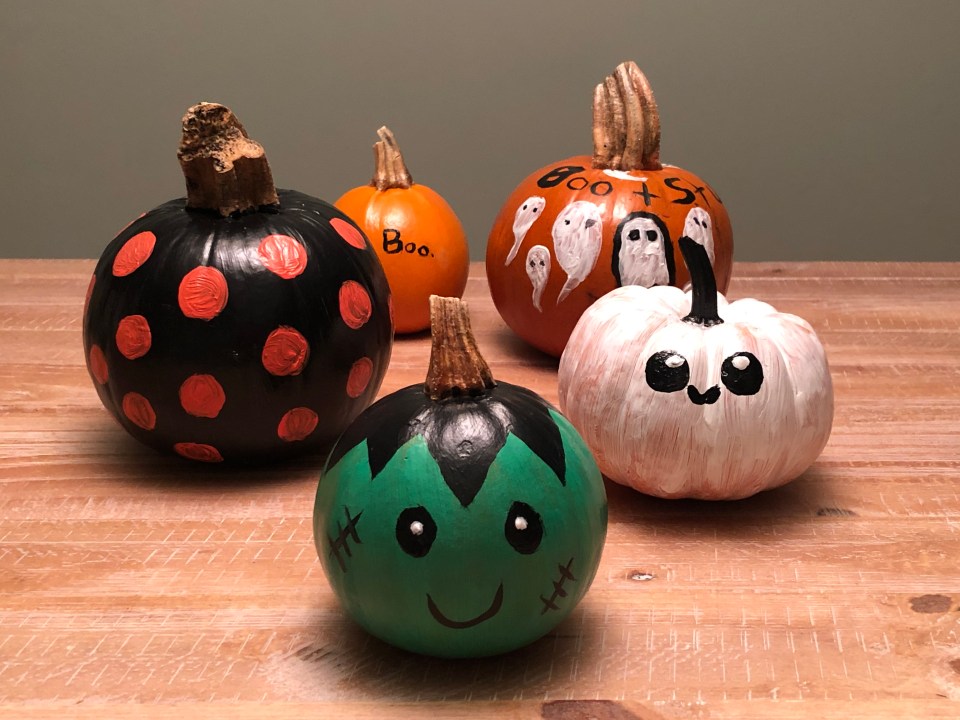 a group of painted pumpkins with one that says boo on it