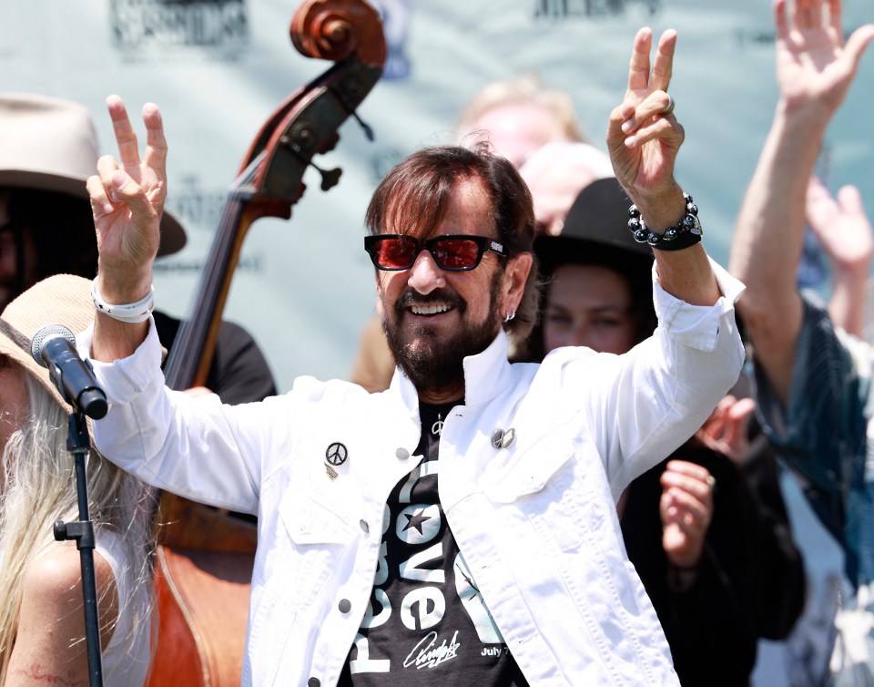 a man giving a peace sign while wearing a shirt that says love