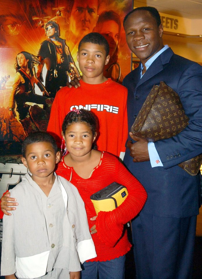 a man and three children pose in front of a sign that says feet