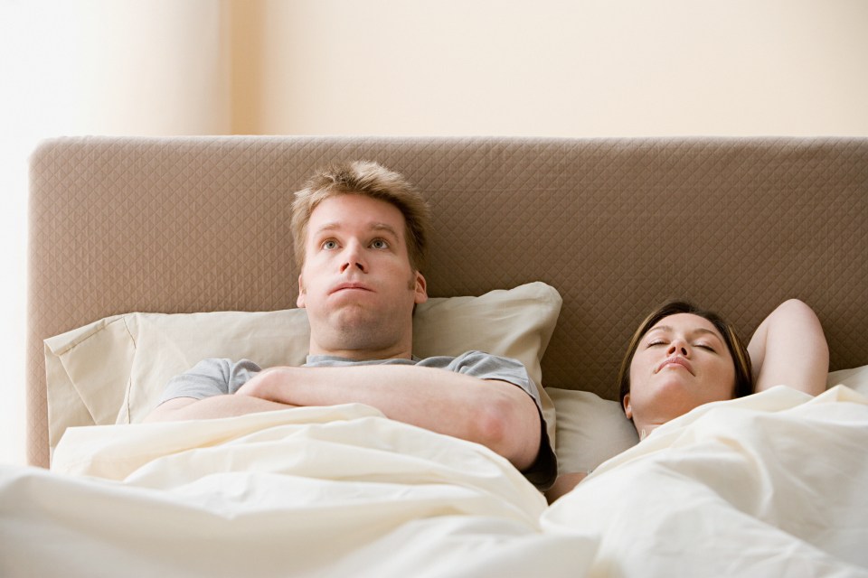 a man and a woman are laying on a bed with their arms crossed