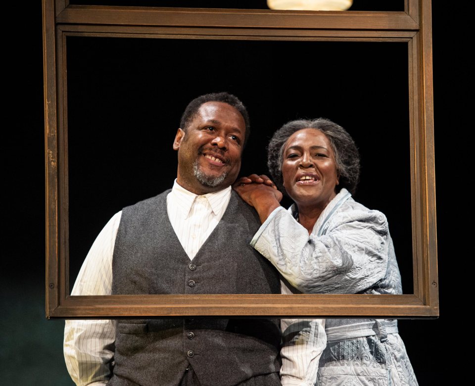 a man and woman are looking out of a window and smiling