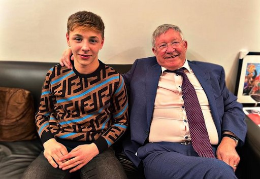 a man in a suit and tie is sitting next to a young boy on a couch .