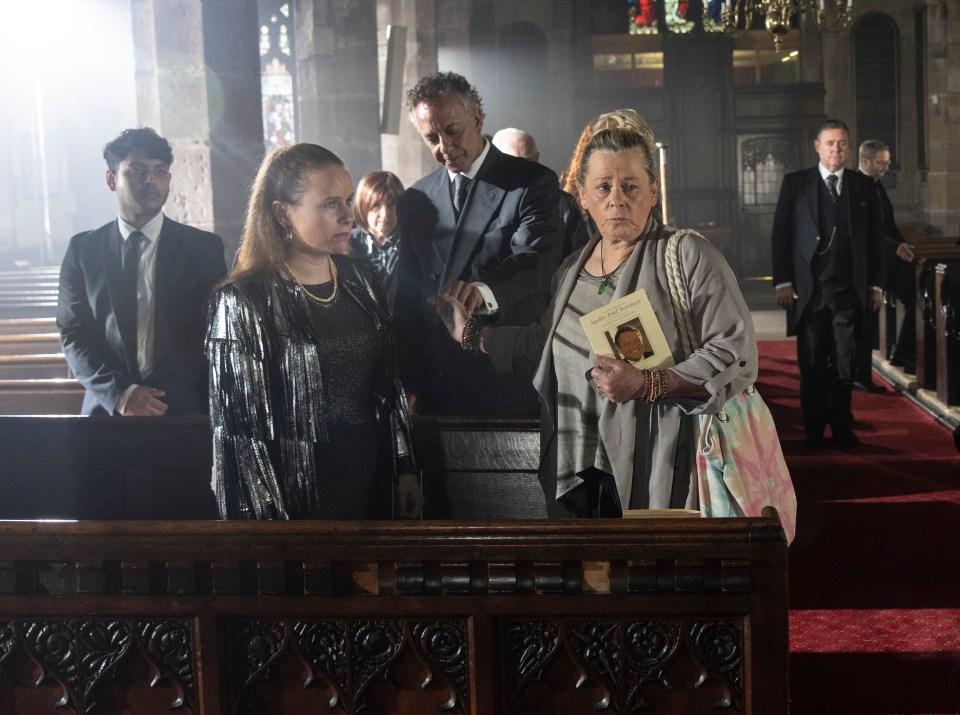 a group of people standing in a church including a woman holding a book that says ' i love you ' on it