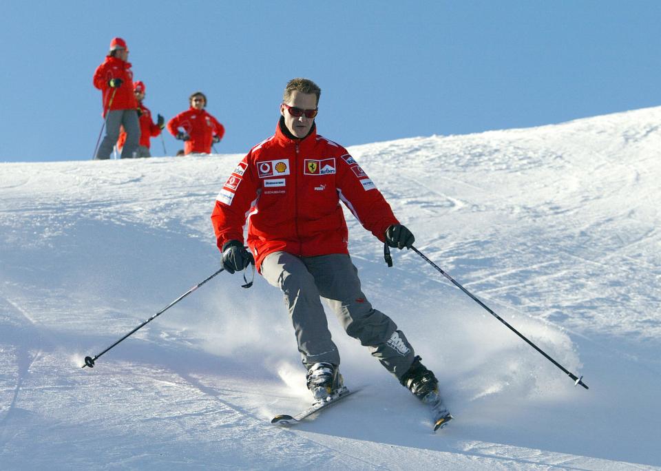 a man skiing down a snowy slope wearing a red jacket that says ferrari on it