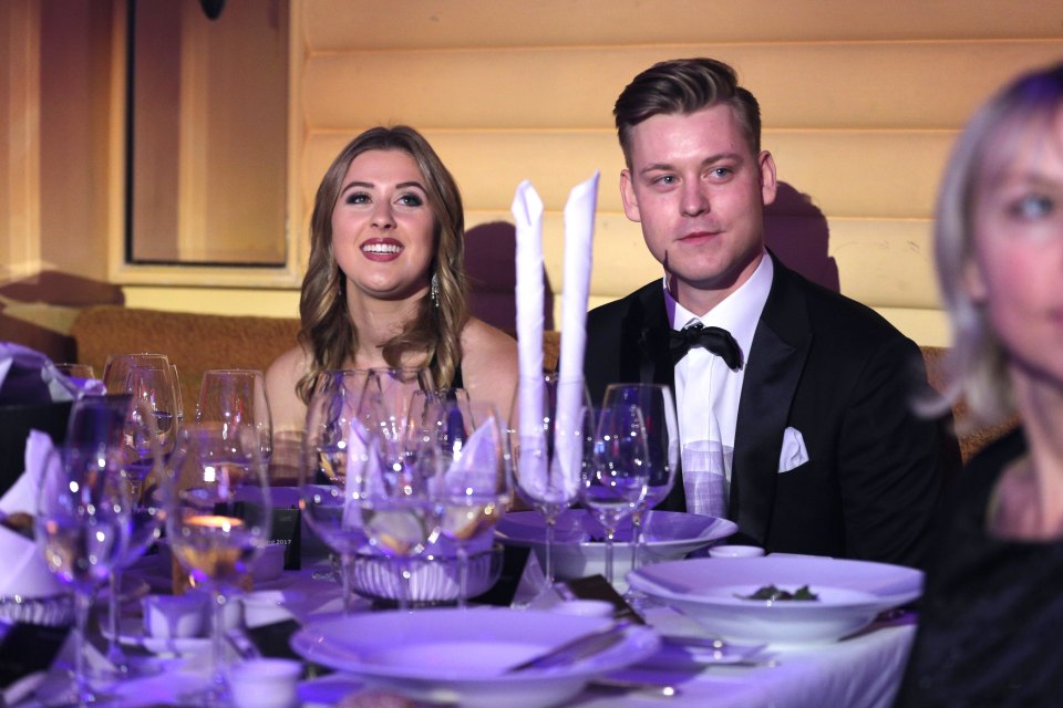 a man and a woman sit at a table with wine glasses