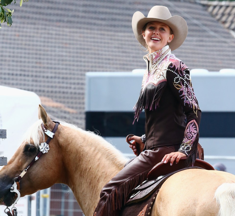 a woman wearing a cowboy hat and a jacket with rhinestones on it