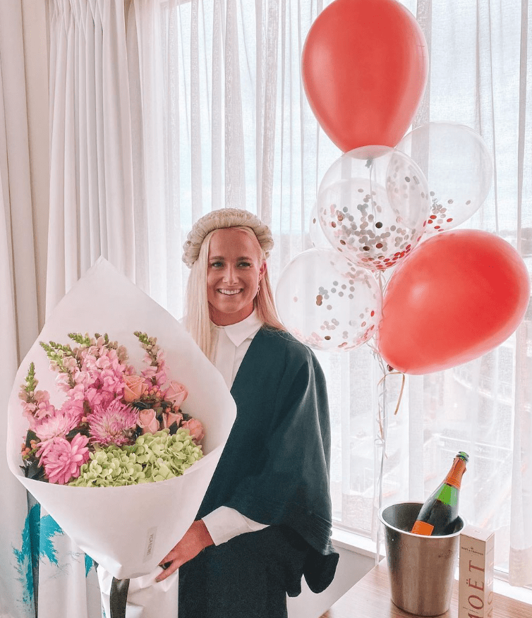 a woman holding a bouquet of flowers next to a bucket of moet