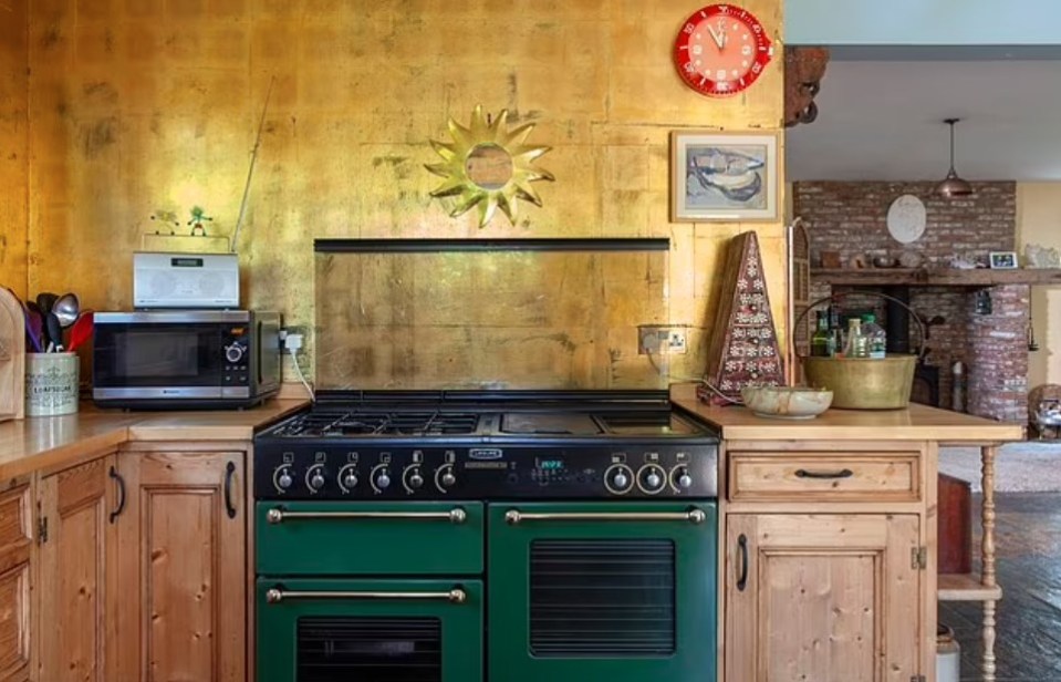 a kitchen with a green stove and a red clock on the wall