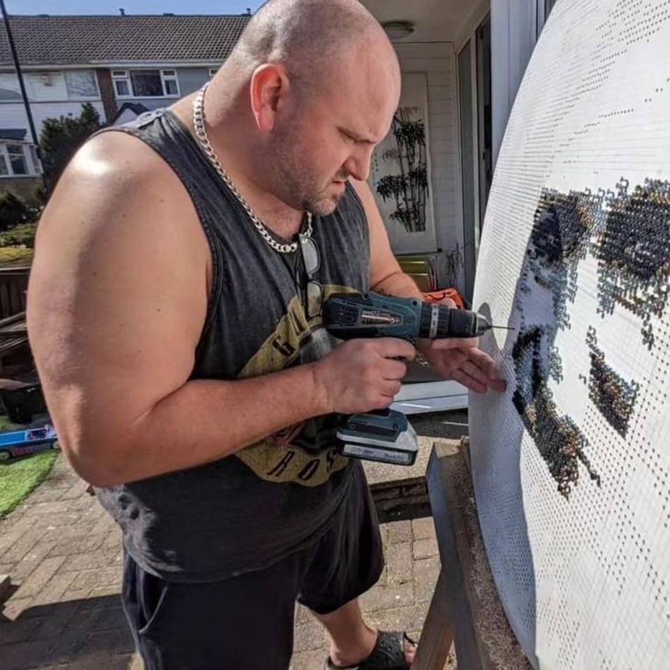 a man is working on a painting with a drill