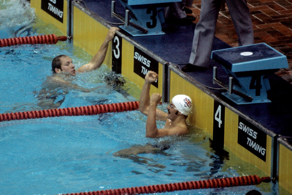 two swimmers are celebrating in front of a swiss timing sign