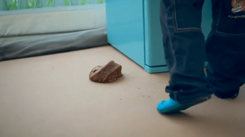 a person standing next to a piece of chocolate on the floor