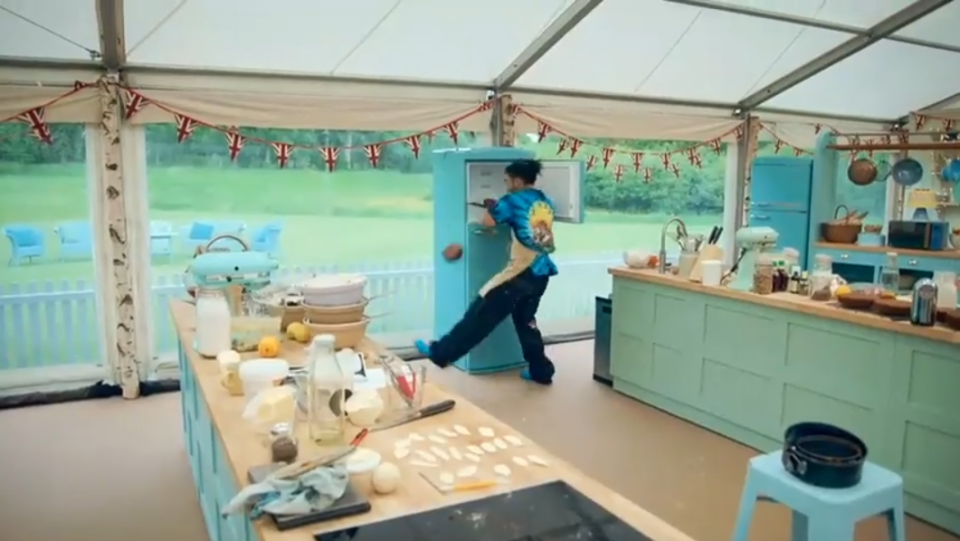 a person standing in a kitchen with flags hanging from the ceiling