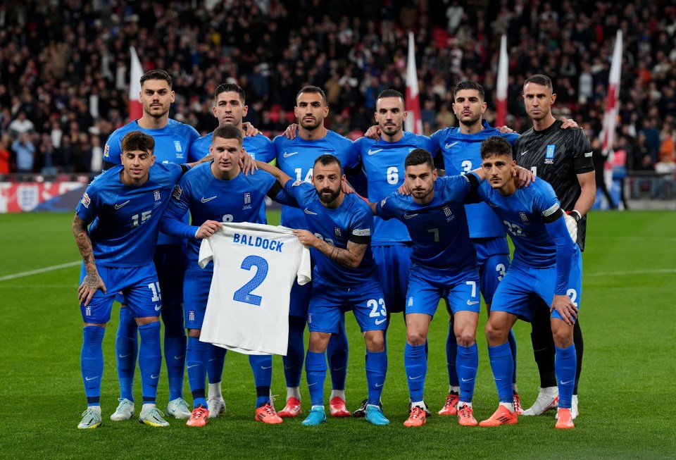 Greece stars hold up Baldock's No2 shirt in tribute