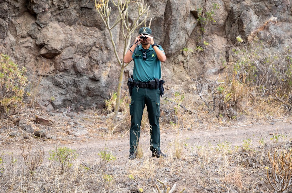 a man in a green uniform is looking through binoculars