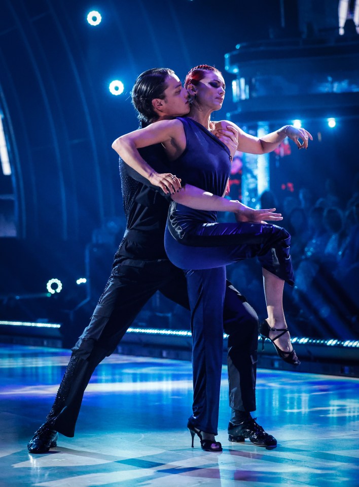 a man kisses a woman on the cheek while they dance