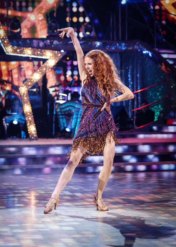 a woman in a purple dress is dancing on a stage