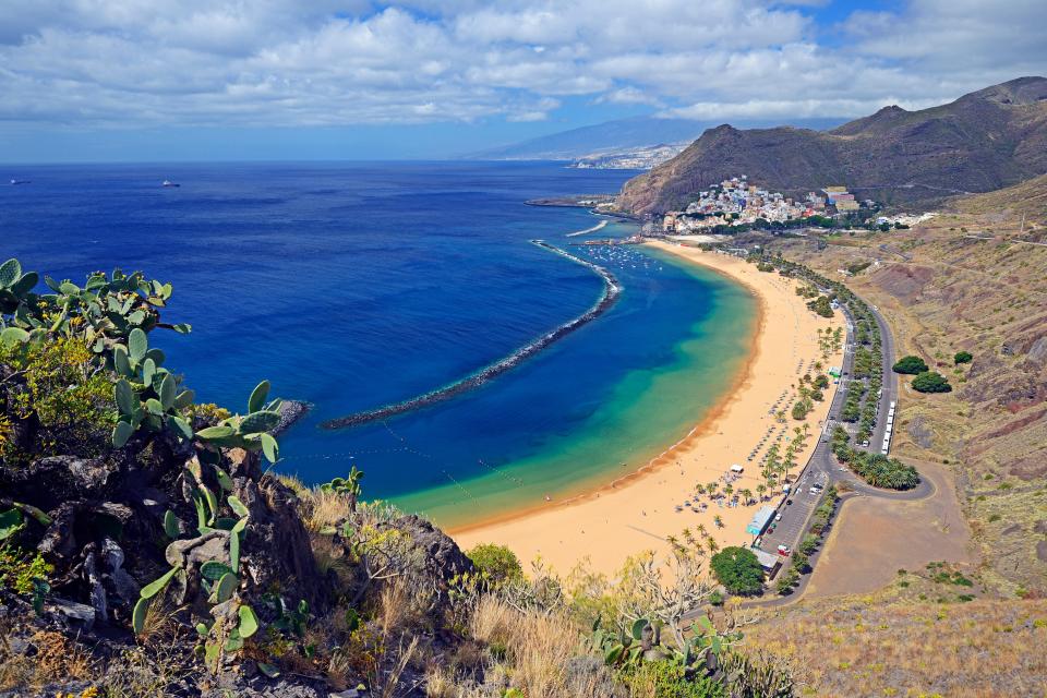 an aerial view of a beach with a city in the background