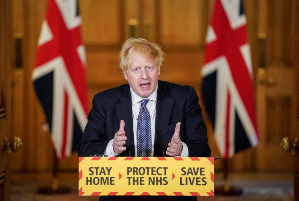 a man stands behind a podium that says stay home protect the nhs save lives