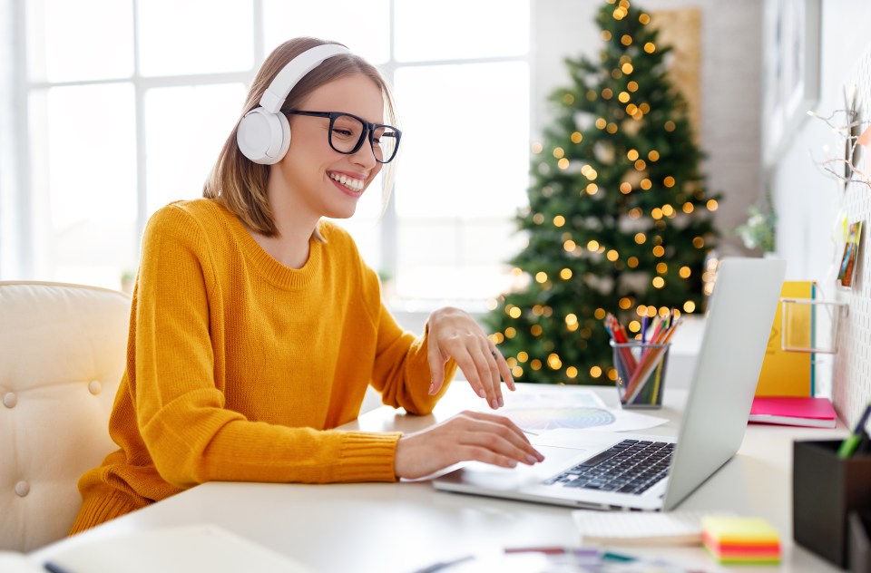 a woman wearing headphones is typing on a laptop