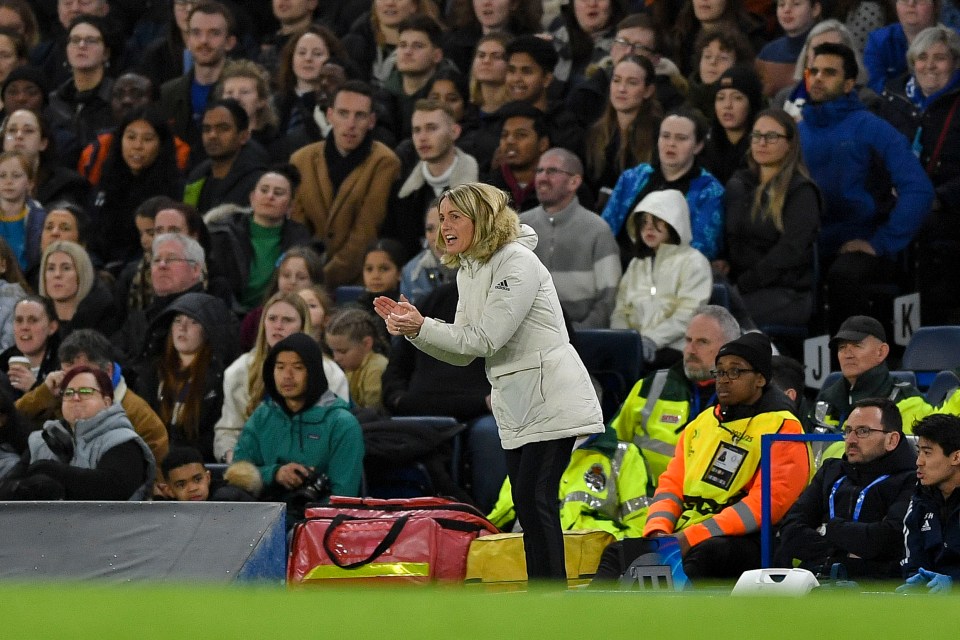 a woman in a white adidas jacket stands in front of a crowd