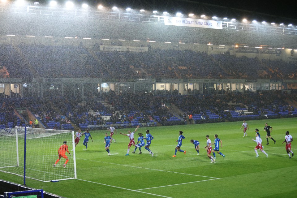 a soccer game is being played in the rain at the recreation ground