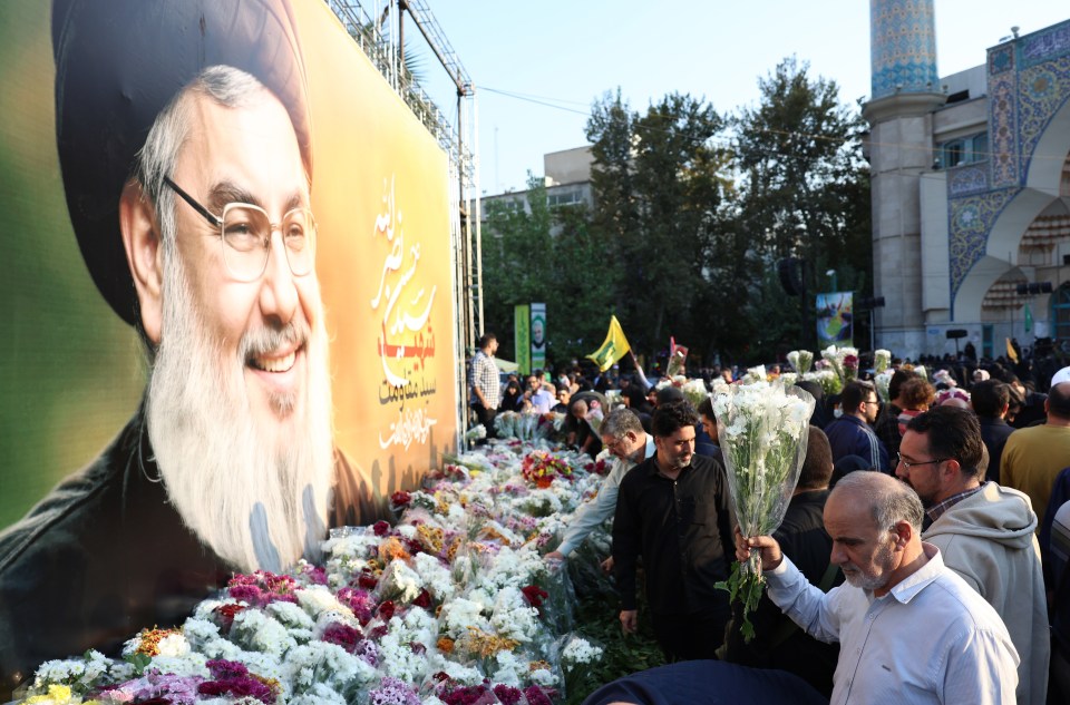 Iranians place flowers next to a pictures of late Hezbollah leader Hassan Nasrallah during an anti-Israel protest in Tehran on Monday