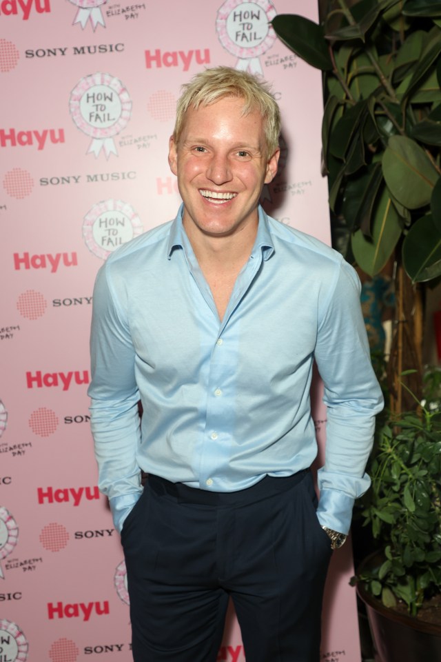 a man stands in front of a pink wall that says hayu