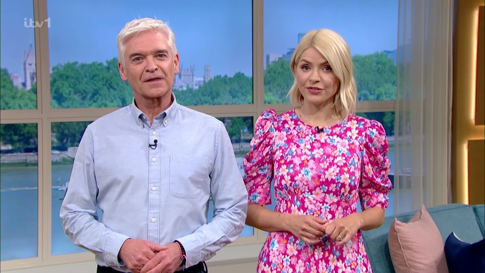 a man in a blue shirt and a woman in a pink dress stand next to each other