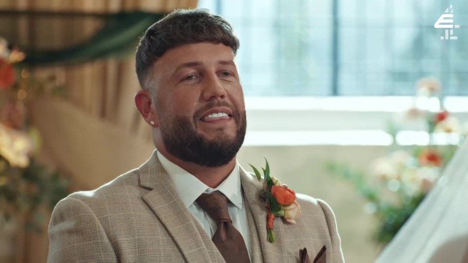 a man in a suit and tie with a flower in his pocket