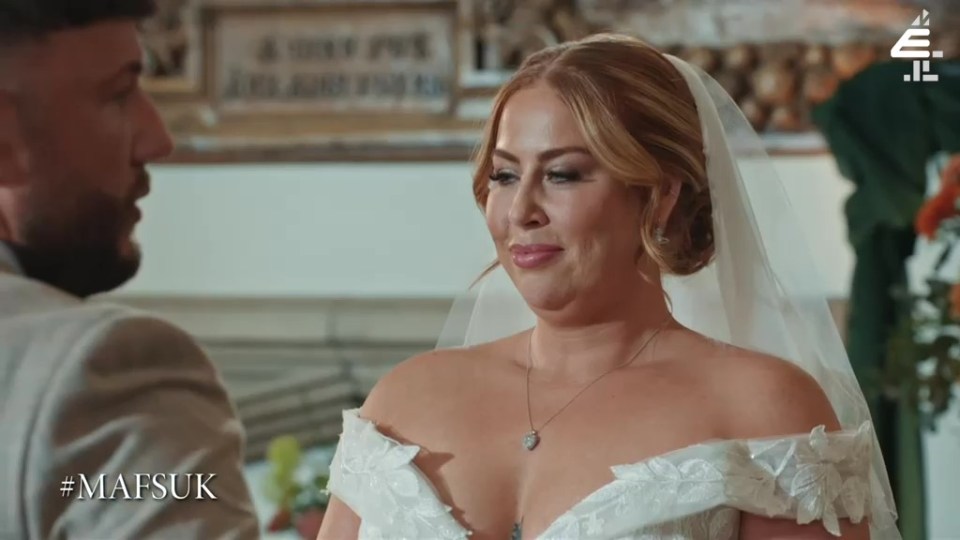 a woman in a wedding dress looks at her groom