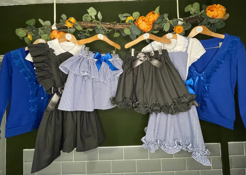 a group of children 's clothes are hanging on a wall