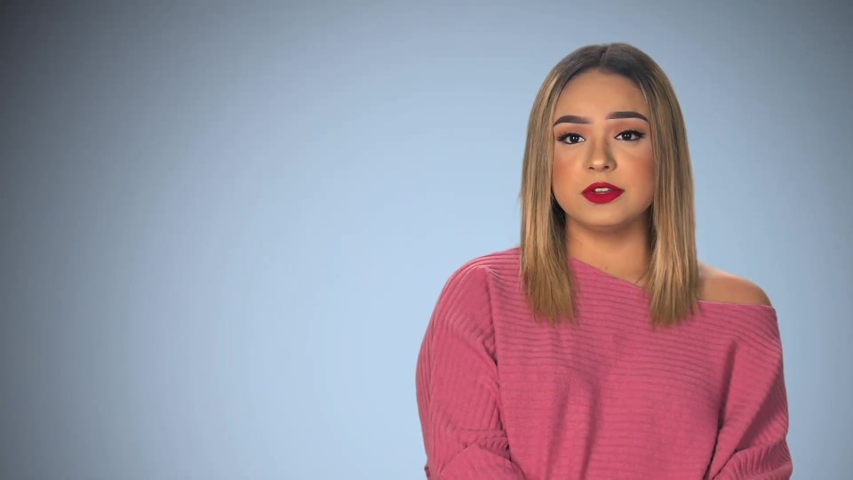 a woman wearing a pink off the shoulder sweater