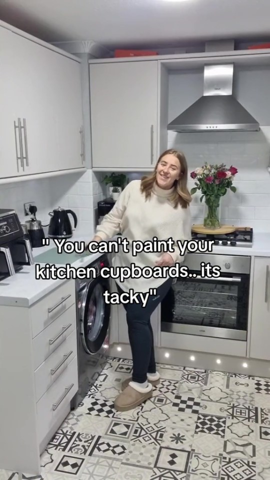 a woman standing next to a washing machine in a kitchen