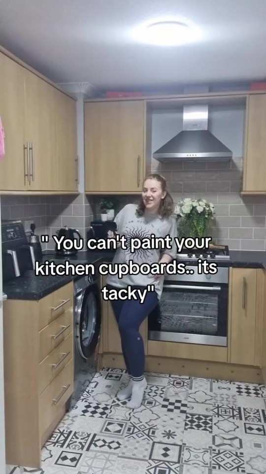 a woman in a kitchen with a caption that says " you can 't paint your kitchen cupboards its tacky "