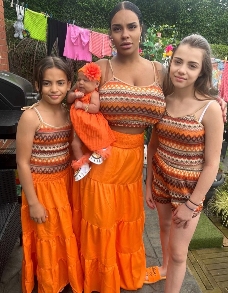 a woman is holding a baby and two girls are wearing matching outfits