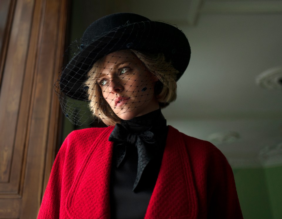 a woman wearing a black hat with a veil on her face