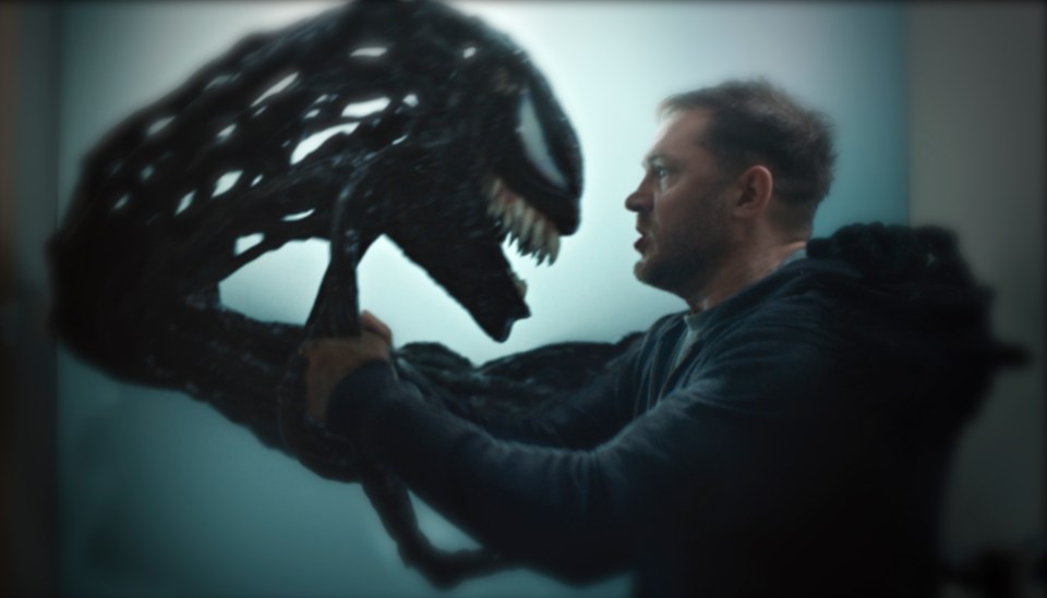 a man in a black shirt is holding a monster in his hands