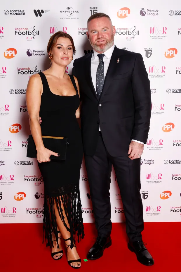 a man and woman pose on a red carpet sponsored by ppl