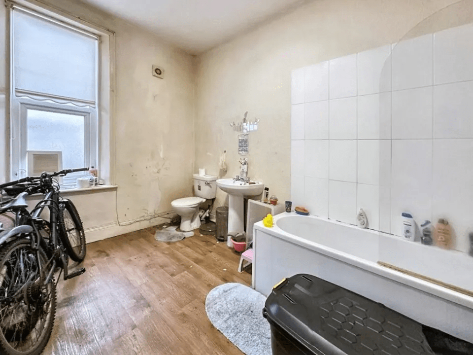 The bathroom, situated at the back of the house, has a panelled bath with shower, a basin, and a toilet