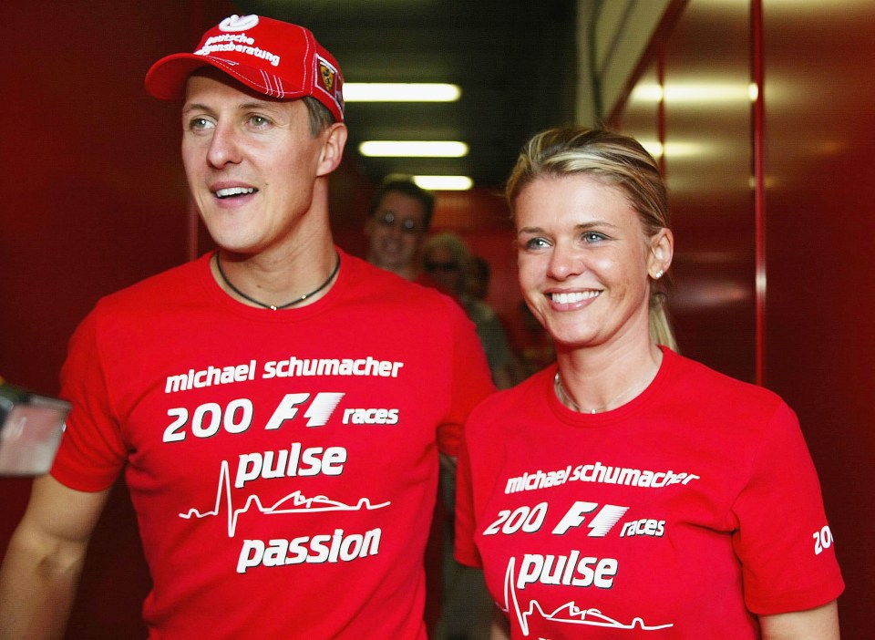 a man and woman wearing red shirts that say michael schumacher 200 f1 races pulse passion