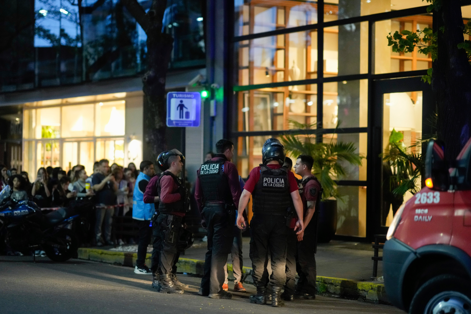 Cops waiting outside the hotel as a heartbroken crowd watches on