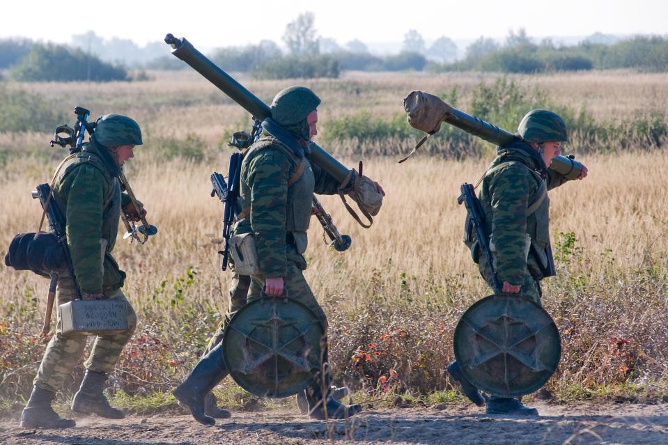 Russian troops carrying weapons across the frontlines