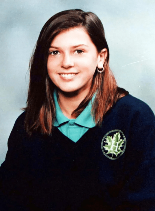 a girl wearing a sweater with a maple leaf on it