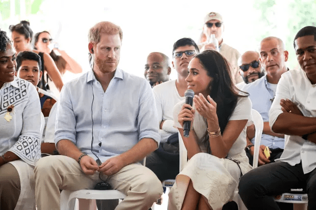 a man and a woman are sitting in front of a microphone with a sign that says ' harry ' on it