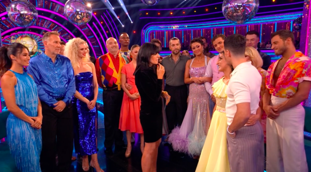 a woman stands in front of a group of people on a stage