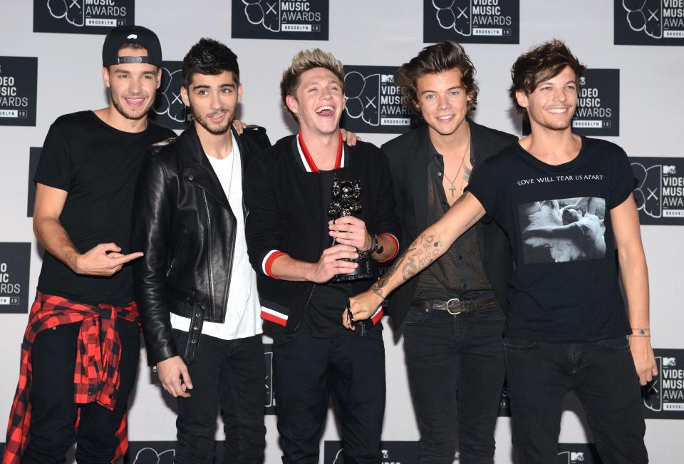 a group of men posing for a picture in front of a wall that says video music awards